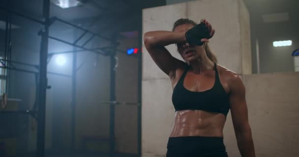 Fitness gesunde Frau müde nach Krafttraining im Fitnessstudio. Zeitlupe: Nahaufnahme eines müden, fitten Models mit Stehen und Entspannen nach intensivem Training. — Stockvideo