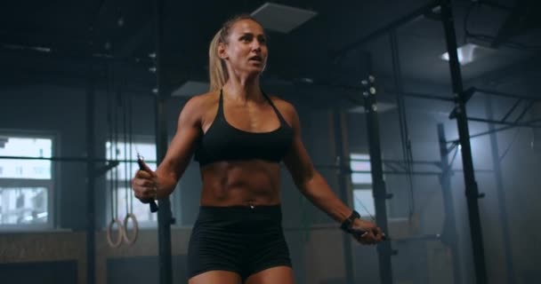 Strong muscular young woman rope skipping as warm up. Fitness concept. Young slim woman jumping with skipping rope in gym. Close-up of female feet jumping in mid air whilst using skipping rope. — Stock Video