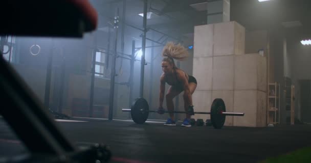 Жінка виконує вправи з важкої атлетики піднімає планку над головою — стокове відео