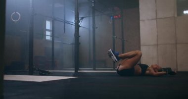 Sıkı bir çalışmadan sonra dişi sporcu yere düştü ama yine de acıların, zorlukların ve yorgunlukların üstesinden gelmeye çalışıyor.