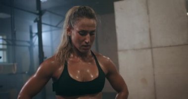 Yorgun ve bitkin bir kadın eğitimden ve ter damlalarından sonra derin derin nefes alır. Egzersizden önce kuvvet ve konsantrasyon oluşumu. Çapraz antrenman.