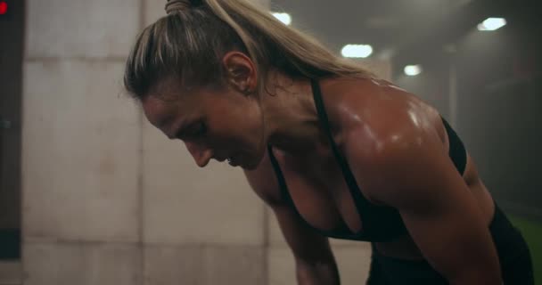 Een sterke vrouw ademt zwaar en herstelt na kruistraining. zweetdruppels. — Stockvideo