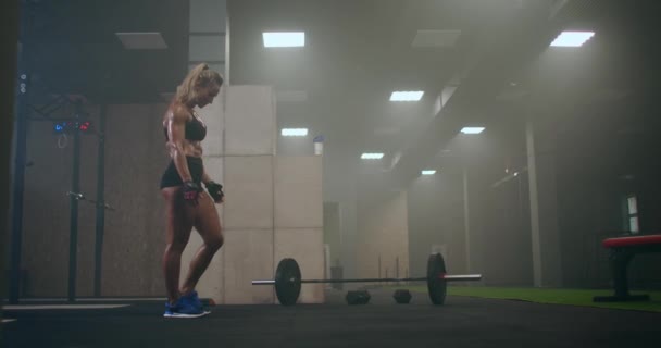 Mulher a preparar-se para o treino. eles estão se preparando para levantar a barra com um peso pesado . — Vídeo de Stock