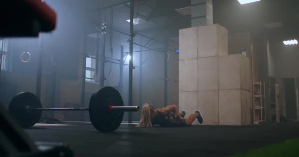 Сильна жінка-спортсменка виконує поштовх UPS з гантелями, що піднімають гантелі над головою після стрибка — стокове відео