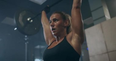 Kadın sporcu spor salonunda antrenman yapıyor, çıtayı yükseltiyor. Güç güçtür. Spor salonunda kaldırma egzersizi yapan kaslı kadın üstsüz atlet..