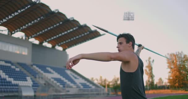 Oštěpový vrhač před hodem. Koncentrace a výdech. Vzrušení a strach před hodem. Sebevědomý pohled a běh na stadionu sportovce provádějící oštěp hod — Stock video