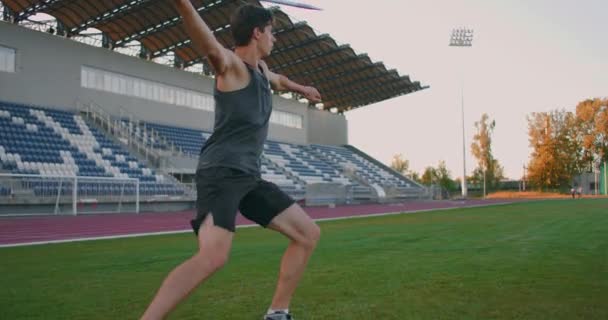 Un atleta di sesso maschile lancia giavellotti contro uno stadio al rallentatore. Atletica giavellotto lancio programma olimpico — Video Stock