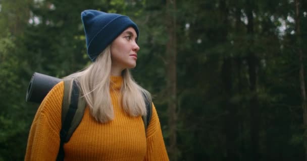 Retrato de câmera lenta: Viajante feliz com mochilas começa sua jornada na floresta ensolarada de outono — Vídeo de Stock
