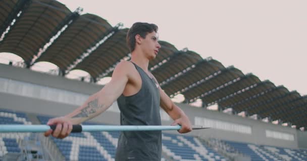 Dardo jogar de volta atleta lançador em pista e evento de campo. Lançamento de dardo de atleta indefinido durante o Campeonato de Atletismo. Esportista praticando dardo jogar contra o céu azul com nuvens — Vídeo de Stock