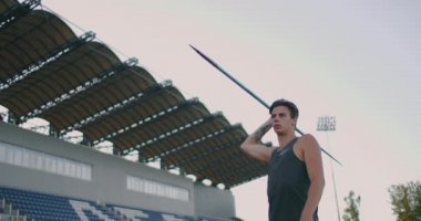 Ağır çekimde: Stadyumda erkek bir atlet koşar ve bir cirit atar. Her yerde olimpiyat oyunları için hazırlık