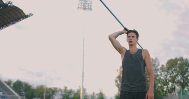 Corrida e lançamento de dardo no estádio. Slo-Mo Shot of Young Man Throwing Javelin. Um homem caucasiano lança dardos no estádio — Vídeo de Stock