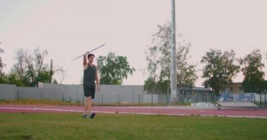 Sporcu cirit atıyor, atletik sahada. Olimpik stadyumda cirit atan erkek sporcu. Profesyonel stadyumdaki atletizm sahasında spor kıyafetleri içinde bir sporcu.