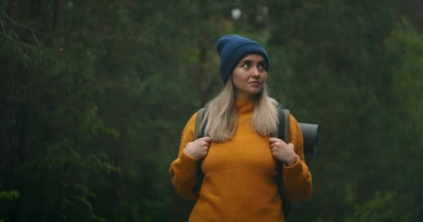 Retrato de câmera lenta: Viajante feliz com mochilas começa sua jornada na floresta ensolarada de outono — Vídeo de Stock