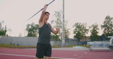 Stadyuma koşup cirit atıyorlar. Mızrak fırlatan genç adamın ağır çekim sahnesi. Stadyumda beyaz bir adam cirit atıyor.