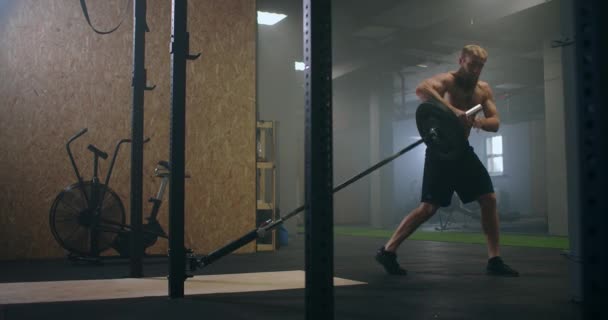 Slow motion: Man gör Single-Arm Landmine Squat-to-Press övning. ung man lyfta skivstång med lätta vikter på gymmet — Stockvideo