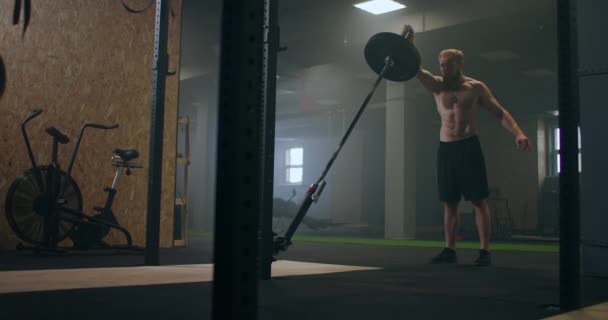 Ένας άντρας που γυμνάζεται στο γυμναστήριο σπρώχνει μια μπάρα νάρκης με το χέρι του — Αρχείο Βίντεο