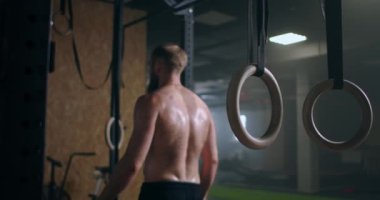 Spor salonundaki yoğun egzersizden sonra yorgun gençler dinleniyor. Yorgun erkek sporcu antrenmandan sonra dinleniyor. Yüzünden bir damla su akıyor, spor salonunda egzersiz yapıyor.