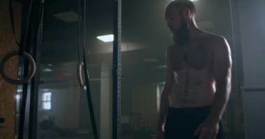 Spor salonundaki yoğun egzersizden sonra yorgun gençler dinleniyor. Yorgun erkek sporcu antrenmandan sonra dinleniyor. Yüzünden bir damla su akıyor, spor salonunda egzersiz yapıyor.