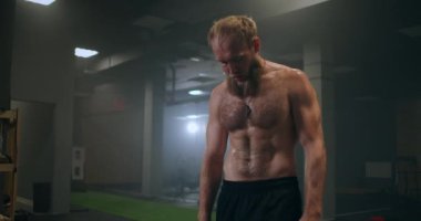 Spor salonunda ağır çekimde buharlı terli yorgun sporcu antrenmandan sonra dinleniyor. Gücünü ve nefesini geri kazan. Motivasyon ve spor