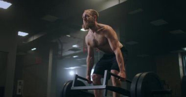 Spor salonunda ağırlık kaldıran bir adam. Romen halterleri ağır çekimde spor salonunda halterle kaldırıyor