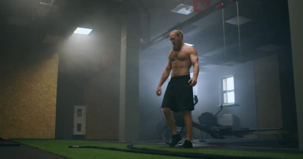 Træt mand efter træning med reb hviler i træningshallen i slowmotion – Stock-video