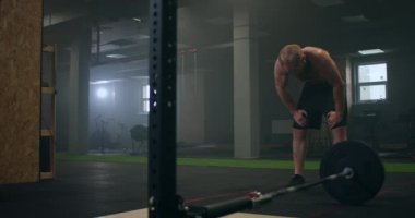 Spor salonundaki yoğun egzersizden sonra yorgun gençler dinleniyor. Yorgun erkek sporcu antrenmandan sonra dinleniyor. Yüzünden bir damla su akıyor, spor salonunda egzersiz yapıyor.