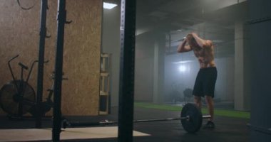 Spor salonundaki yoğun egzersizden sonra yorgun gençler dinleniyor. Yorgun erkek sporcu antrenmandan sonra dinleniyor. Yüzünden bir damla su akıyor, spor salonunda egzersiz yapıyor.