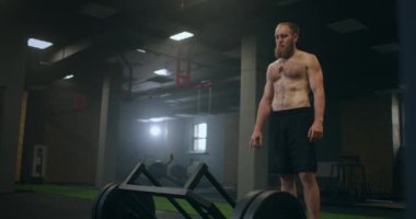 Yorgun bir adam ağırlık kaldırdıktan sonra dinlenir, vilnay egzersizleri ölü kaldırır. Eğitimden önce konsantrasyon hazırlanıyor ve ayarlanıyor. Spor salonunda buharlı bir sporcunun ruh hali ve derin nefesi.