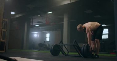 Yorgun bir adam ağırlık kaldırdıktan sonra dinlenir, vilnay egzersizleri ölü kaldırır. Eğitimden önce konsantrasyon hazırlanıyor ve ayarlanıyor. Spor salonunda buharlı bir sporcunun ruh hali ve derin nefesi.