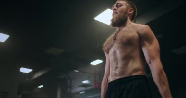 Spor salonunda ağırlık kaldıran bir adam. Romen halterleri ağır çekimde spor salonunda halterle kaldırıyor