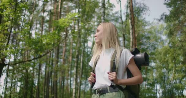 Vit blond kvinna utforskar glänta med ormbunkar i skogen. vandringskvinna gå i regnskogs djungel. Flicka vandrare promenader med ryggsäck genom tät regnskog natur — Stockvideo