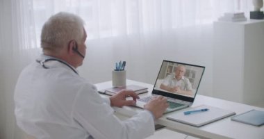 Kardiyolog yaşlı bir hastaya çevrimiçi danışmanlık yapıyor. Hastanedeki uzman doktorunu görüntülü konuşma ve uzaktan danışma ile arıyor.