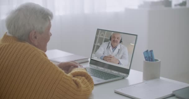 Médecin de famille consulte l'homme âgé à distance par vidéoconférence en ligne, vieux patient rester à la maison et médecin à l'écoute — Video