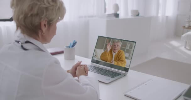 Gammal pensionerad man kallar till läkare genom videokonferens, kvinna tittar på honom på displayen och lyssna symptom — Stockvideo