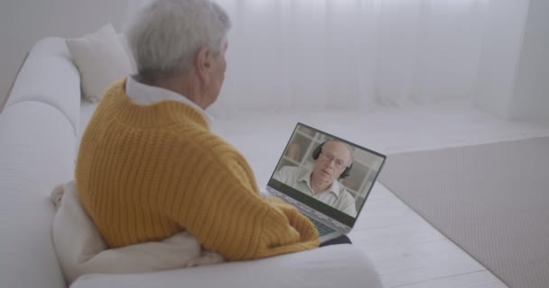 L'homme âgé regarde la vidéo de formation à l'affichage d'ordinateur portable, l'homme donne des conférences au webinaire, technologie moderne — Video