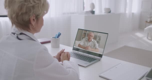 Ayuda médica en línea, paciente está llamando al hospital por videoconferencia y hablar con el médico femenino, la comunicación a distancia — Vídeo de stock