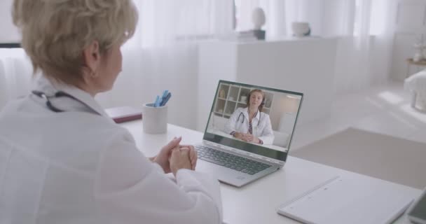 Pasante médica mujer está consultando con su maestro por videollamadas, médico mujer con experiencia está escuchando y ayudando a los estudiantes — Vídeos de Stock