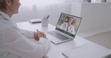 Genç stajyer hekim kadın görüntülü konuşma ile deneyimli kadın doktoru danışmanlık, konuşma ve danışmanlık için arıyor.