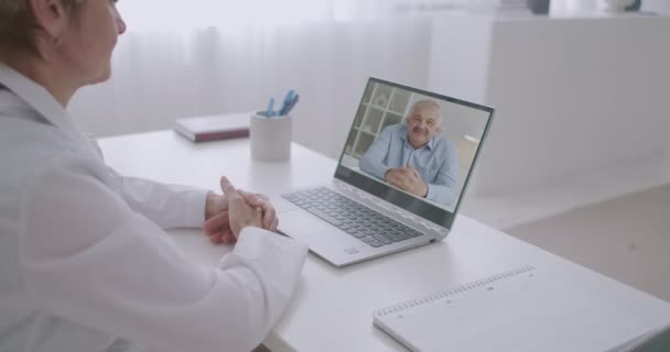 Medisch consult online via video chat, man van middelbare leeftijd roept zijn therapeut of cardioloog om kliniek van thuis uit — Stockvideo