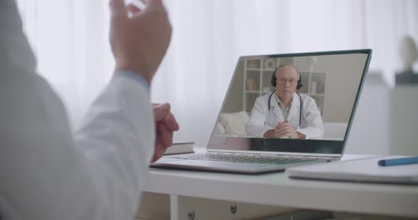 Главный врач и медицинский специалист общаются онлайн на ноутбуке с интернетом, крупным планом рук — стоковое видео