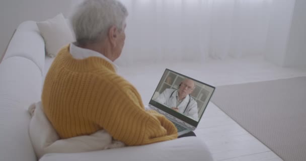 現代の遠隔医療サービス老人は家にいてビデオ通話で医師と相談していますコロナウイルスのパンデミック — ストック動画