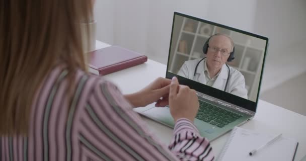 Молодая мама просматривает видео с лекцией педиатра мужчина, электронное обучение и образование для молодых родителей — стоковое видео