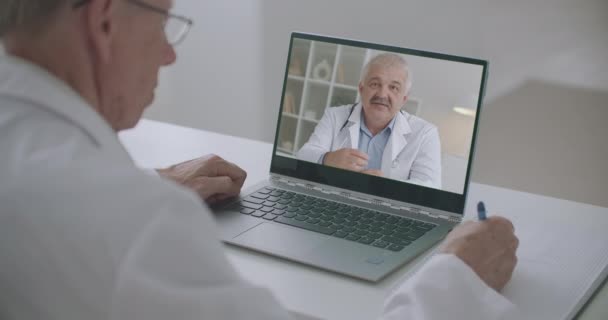 Mužský lékař prohlíží online webinář profesora medicíny notebookem, on-line školení — Stock video