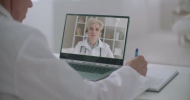 Çevrimiçi sağlık uzmanları konferansı, erkek kadın doktor ve notları dinliyor, yüz üstü bilgisayar ekranında