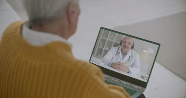 Lekarz konsultuje się z pacjentami w podeszłym wieku przez połączenie wideo, emeryt zostaje w domu podczas pandemii koronawirusa — Wideo stockowe