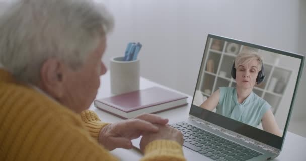 Äldre man är konsult med psykolog genom online-konferens, stanna hemma, med hjälp av bärbar dator med internet — Stockvideo