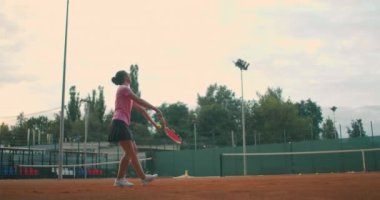 Ağır çekim: Beyaz tenli genç bayan tenisçi bir oyun ya da antrenman sırasında hizmet veriyor. Tenis oyuncusu Clay Court 'ta.
