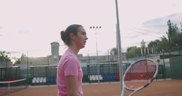 Tenis profesional, chica deportista determinada golpeando raqueta en la pelota en la cancha roja profesional durante el partido al aire libre, cámara lenta — Vídeos de Stock