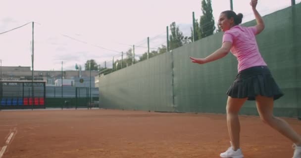 Joueuse de tennis en action pendant le match sur le stade professionnel. Elle porte des vêtements de sport sans marque. Le stade — Video