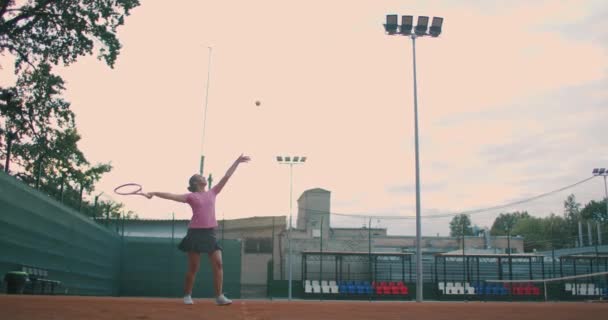 Tiefansicht in Zeitlupe einer jungen Tennisspielerin, die sich auf ein Tennismatch vorbereitet. Eine Sportlerin schlägt beim Sport mit voller Wucht auf einen Ball ein. Kommerzielle Nutzung — Stockvideo